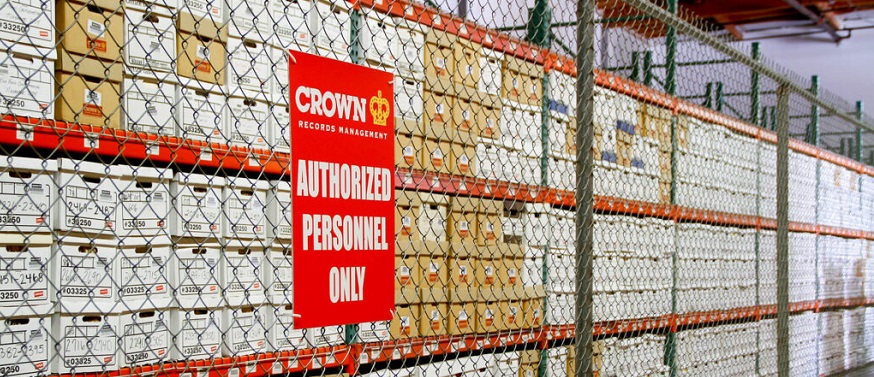 boxes on racks in a warehouse behind a sign that reads, 'Authorised Personnel Only'